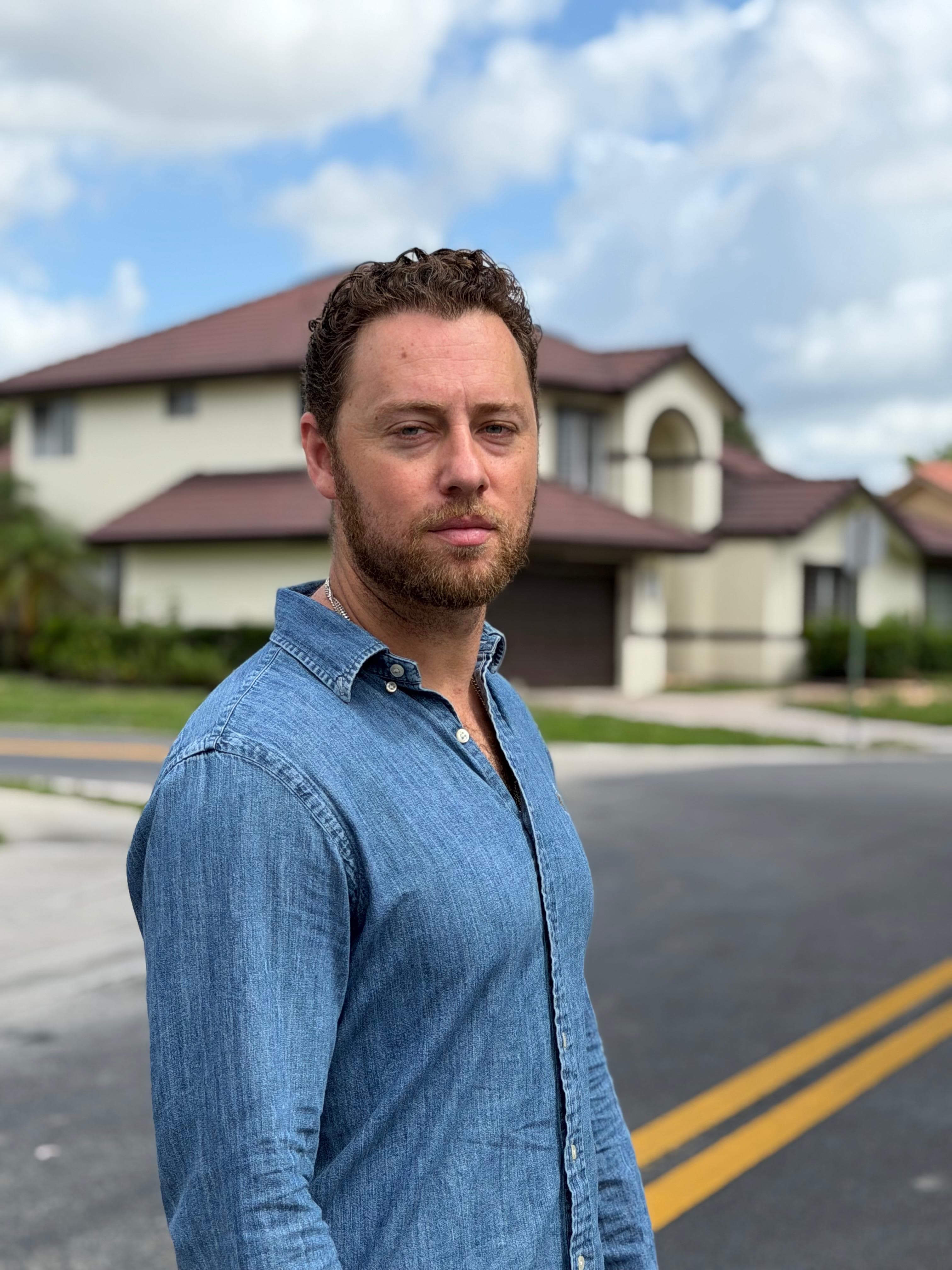 Jonah Stevens standing on a residential street in front of a two-storey home